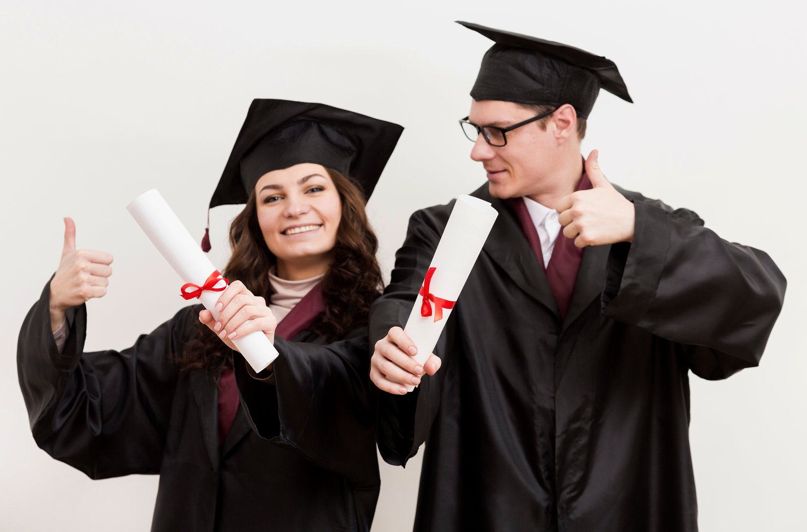 Estudiantes graduados celebrando con birretes